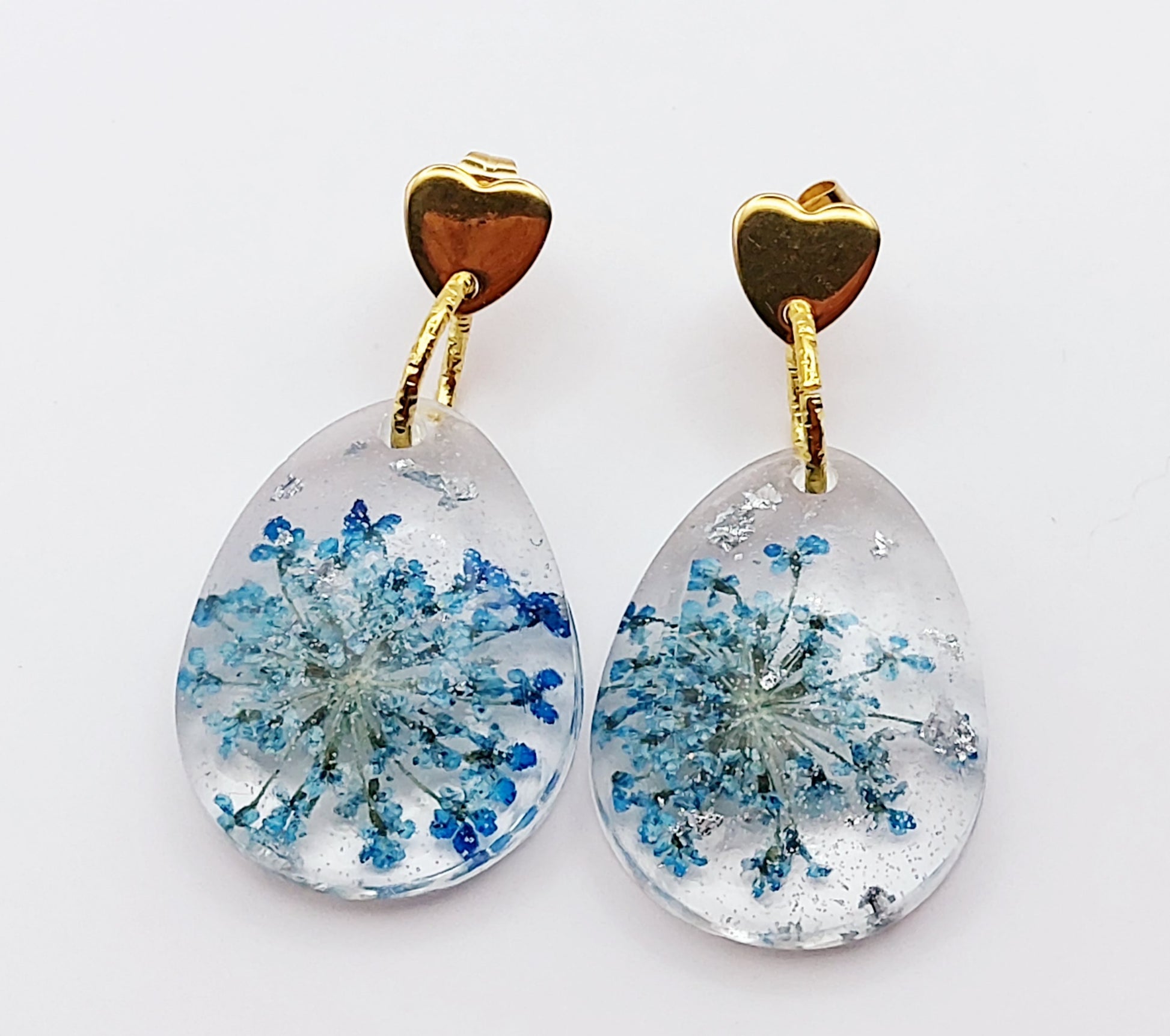 Boucles d'oreilles en résine "Fleur bleue dans une goutte d'eau", avec feuille d'argent, apprêts en forme de coeur