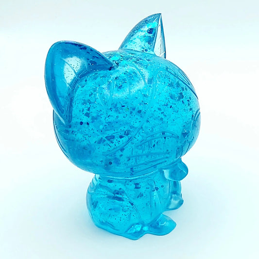 Figurine Chat Kawaii en résine époxy, turquoise translucide et paillettes. Gros plan.