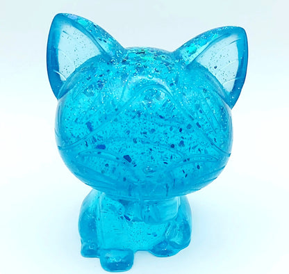 Figurine Chat Kawaii en résine époxy, turquoise translucide et paillettes. Vue de face.