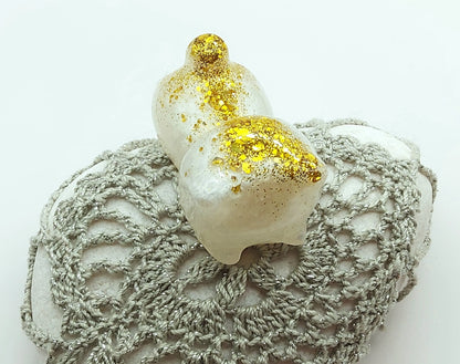 Figurine "Chaton couché" en résine époxy, blanc et paillettes dorées.