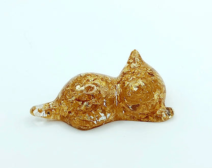 Figurine "Chaton couché" en résine époxy, transparent et feuille d'or. Vue de côté.