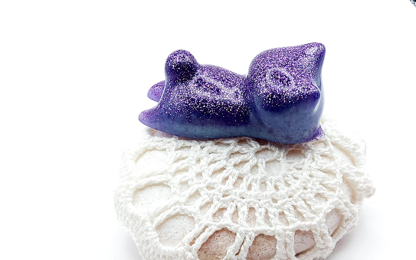 Figurine "Chaton couché" en résine époxy, violet et paillettes, posé sur un galet