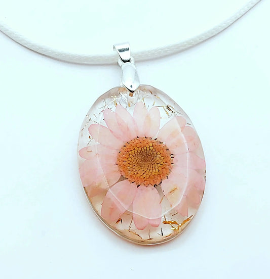 Pendentif OVALE en résine époxy. Fleur rose et paillettes dorées. Cordon en coton ciré blanc. PRETTY RESINE