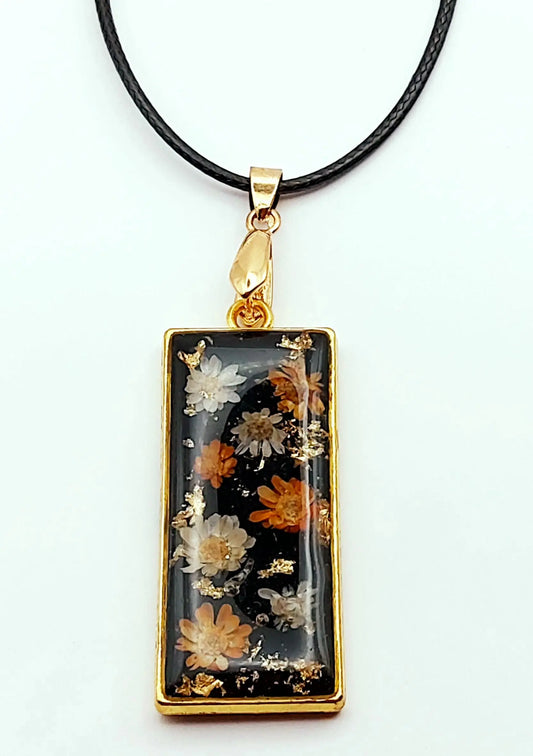 Pendentif Rectangulaire orné de fleurs séchées - Doré, fond noir, fleurs oranges et blanches - Cordon en coton ciré noir - PRETTY RESINE