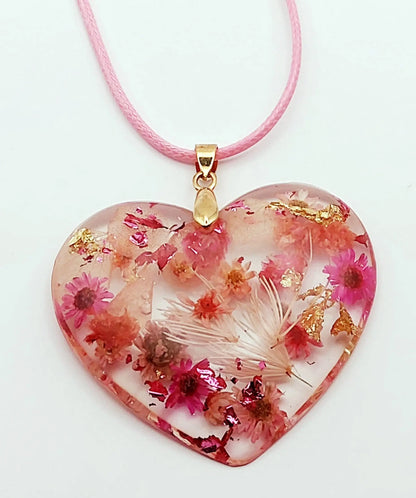 Pendentif "Coeur fleuri" en résine époxy, fleurs roses. Gros plan.