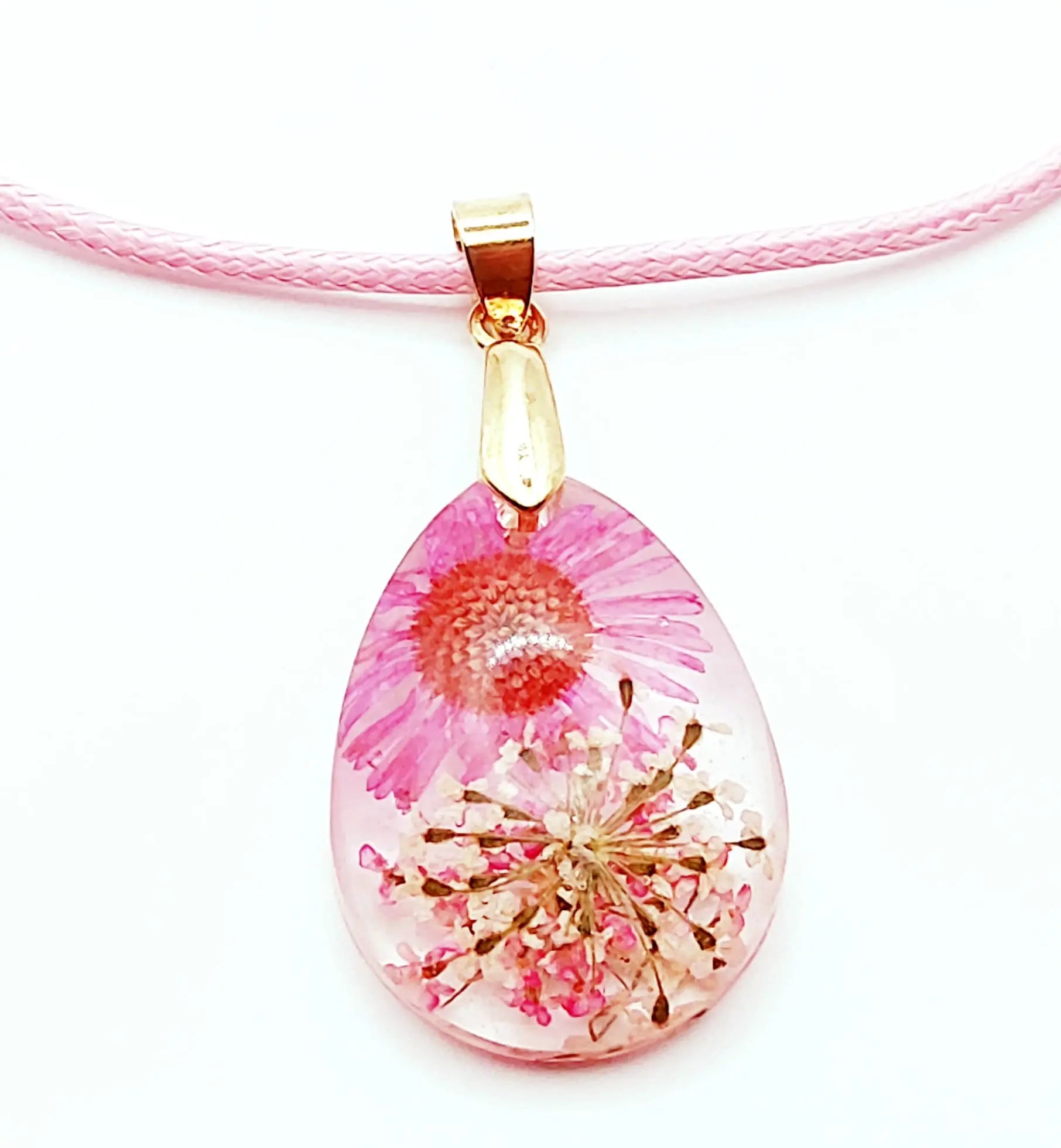 Pendentif "Goutte d'eau" en résine époxy. Fleurs roses et blanches. Cordon en coton ciré rose pastel.