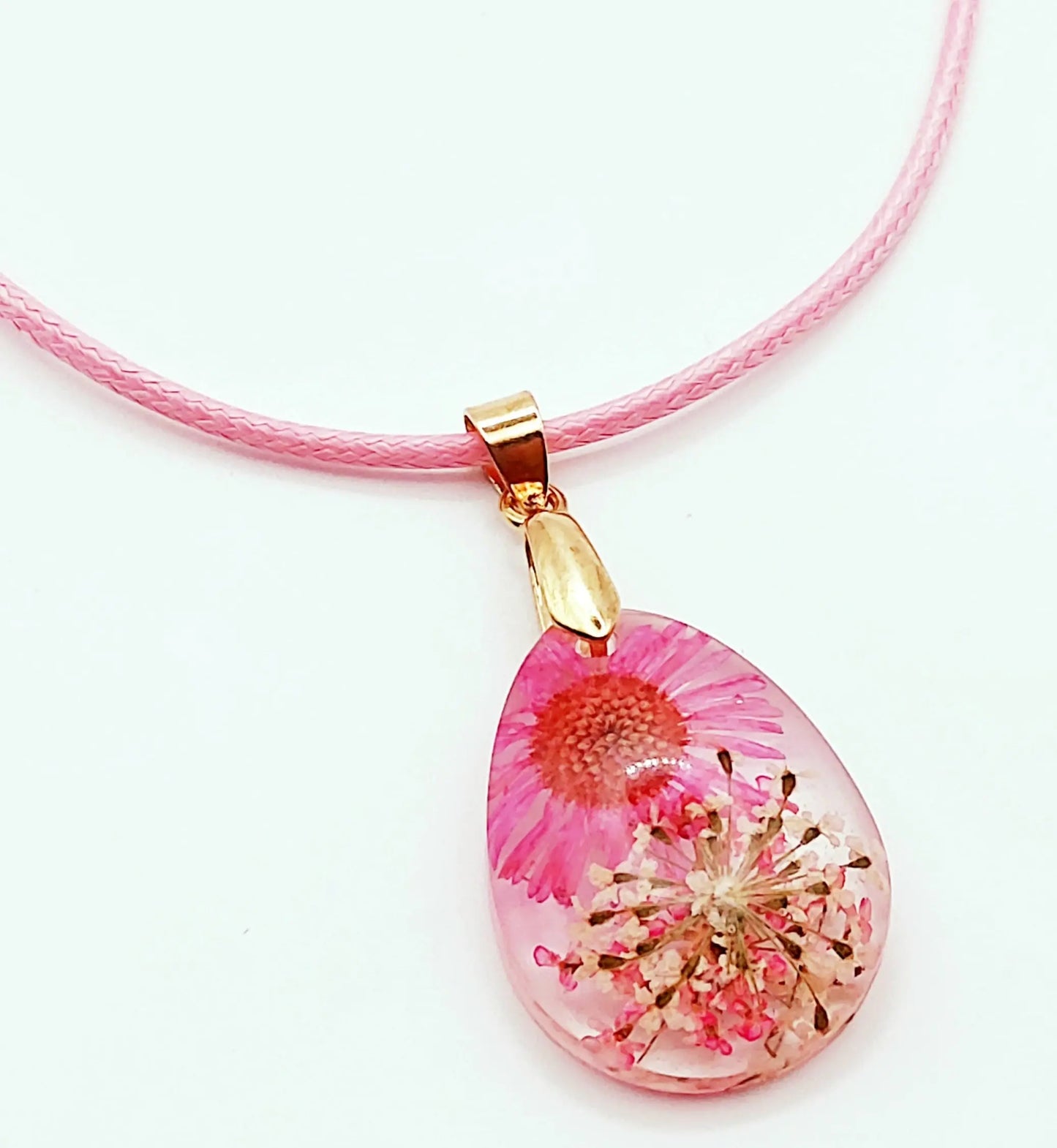 Pendentif "Goutte d'eau" en résine époxy. Fleurs roses et blanches. Cordon en coton ciré rose pastel.