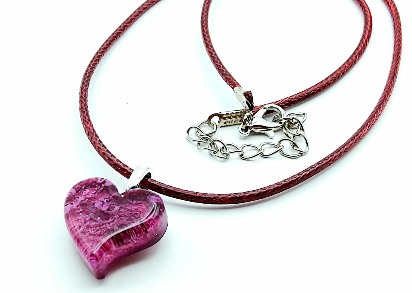 Pendentif "Mini Coeur" en résine époxy. Effet pétri bordeaux et rose. Cordon en coton ciré bordeaux. Plan large.