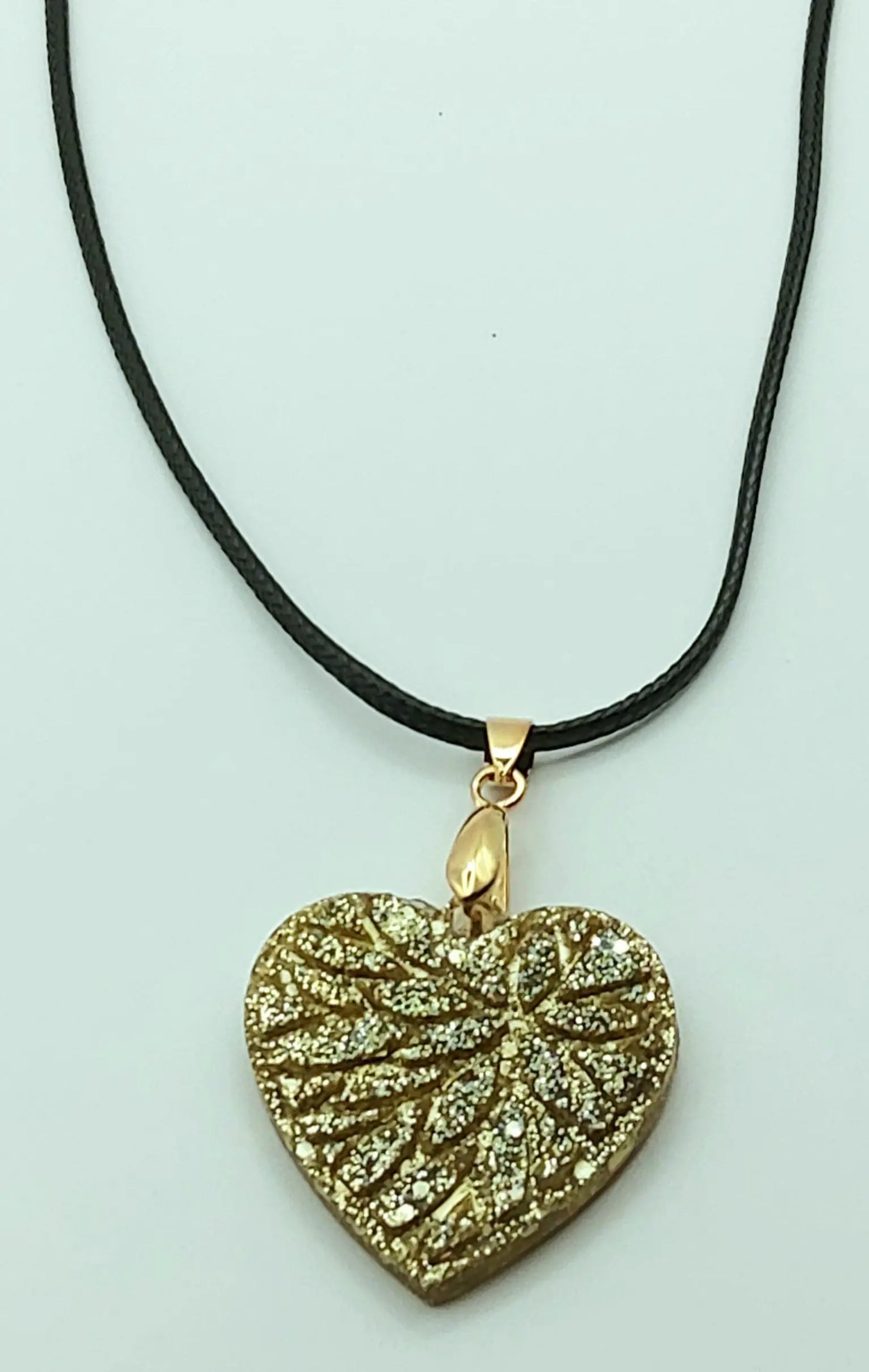 Pendentif "Petit Coeur" en résine époxy, paillettes dorées. Cordon en coton ciré noir.