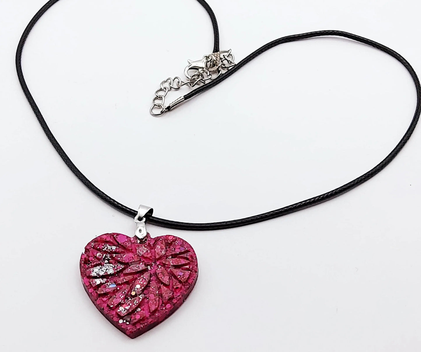 Pendentif "Petit Coeur" en résine époxy, paillettes fuchsia et argent. Plan large.