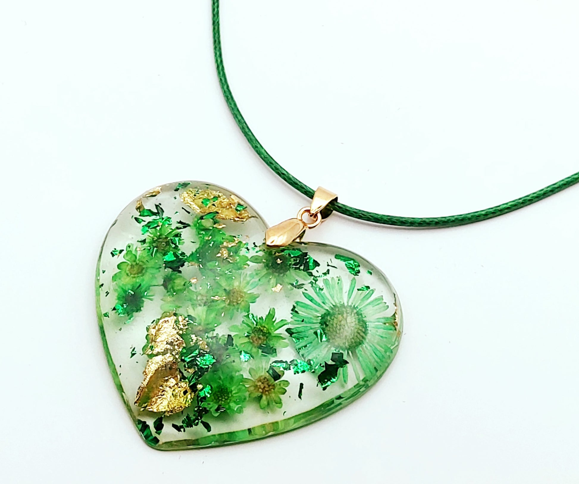 Pendentif "Coeur Fleuri" en résine époxy, fleurs vertes, gros plan. Cordon en coton ciré vert.