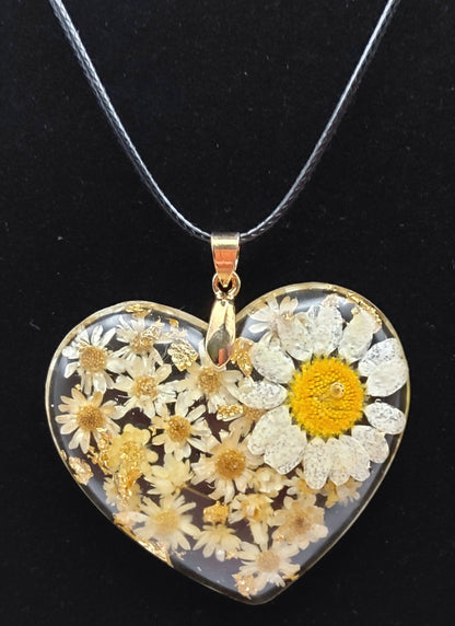 Pendentif "Coeur Fleuri" en résine époxy, fleurs blanches. Gros plan sur fond noir.