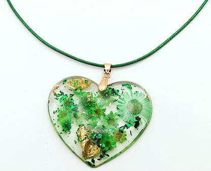 Pendentif "Coeur Fleuri" en résine époxy, fleurs vertes, gros plan. Cordon en coton ciré vert.