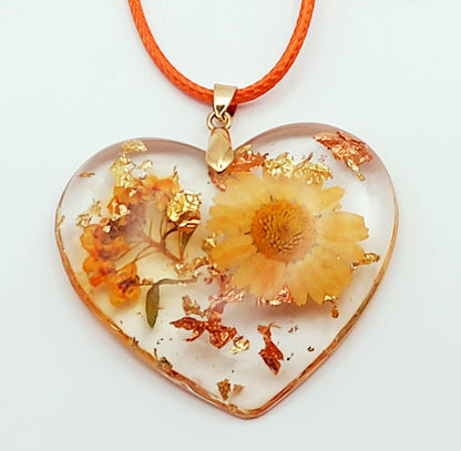 Pendentif "Coeur fleuri" en résine époxy, fleurs oranges. Gros plan.