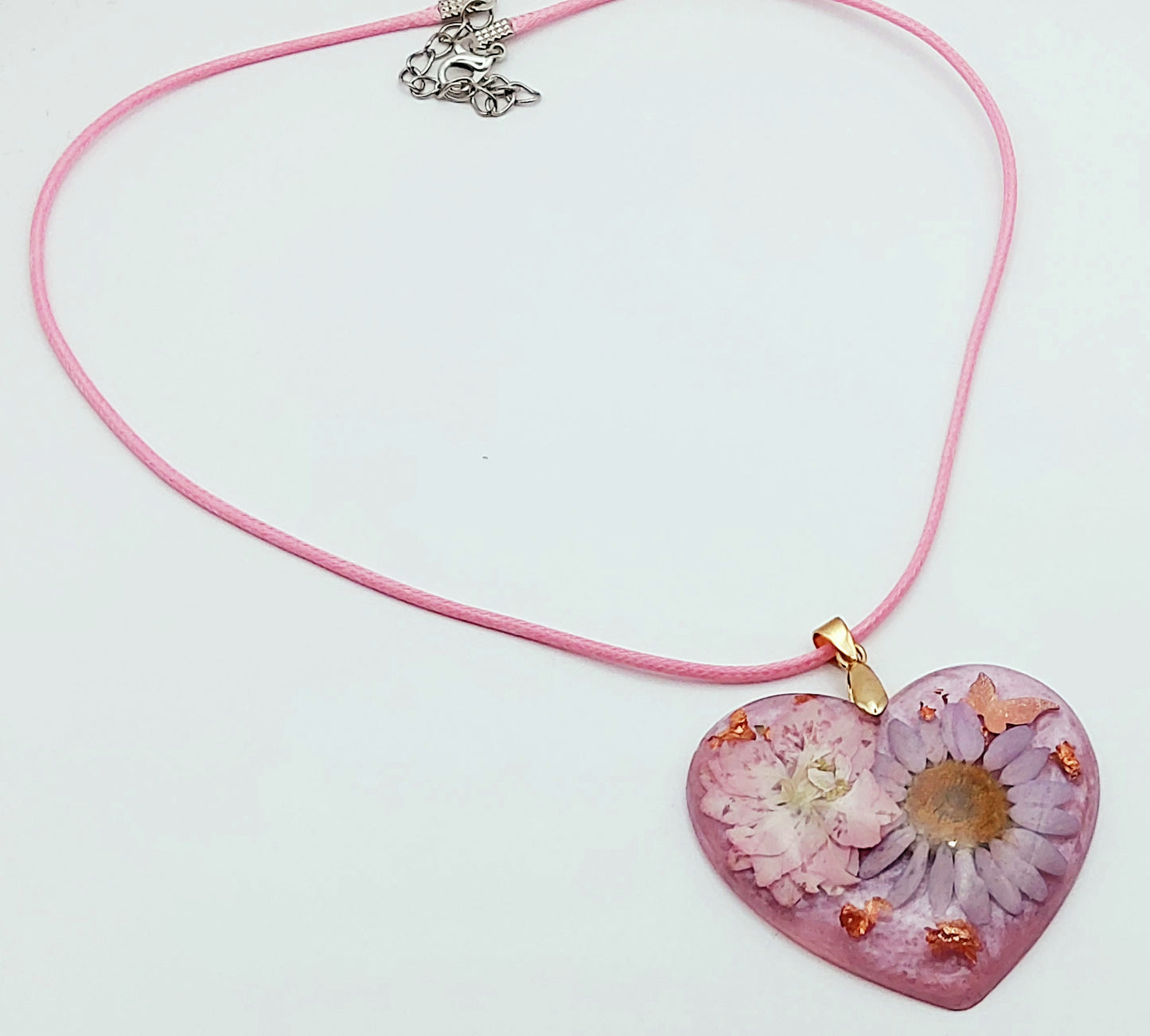 Pendentif Coeur fleuri en résine époxy, fleurs mauves, papillon et feuille de cuivre. Cordon en coton ciré mauve