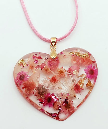 Pendentif "Coeur fleuri" en résine époxy, fleurs roses. Gros plan.