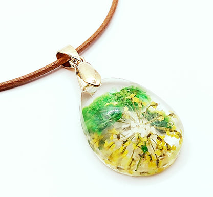 Pendentif "Goutte d'eau" en résine époxy. Fleurs vertes et jaunes. Cordon en coton ciré marron. Vue de côté.