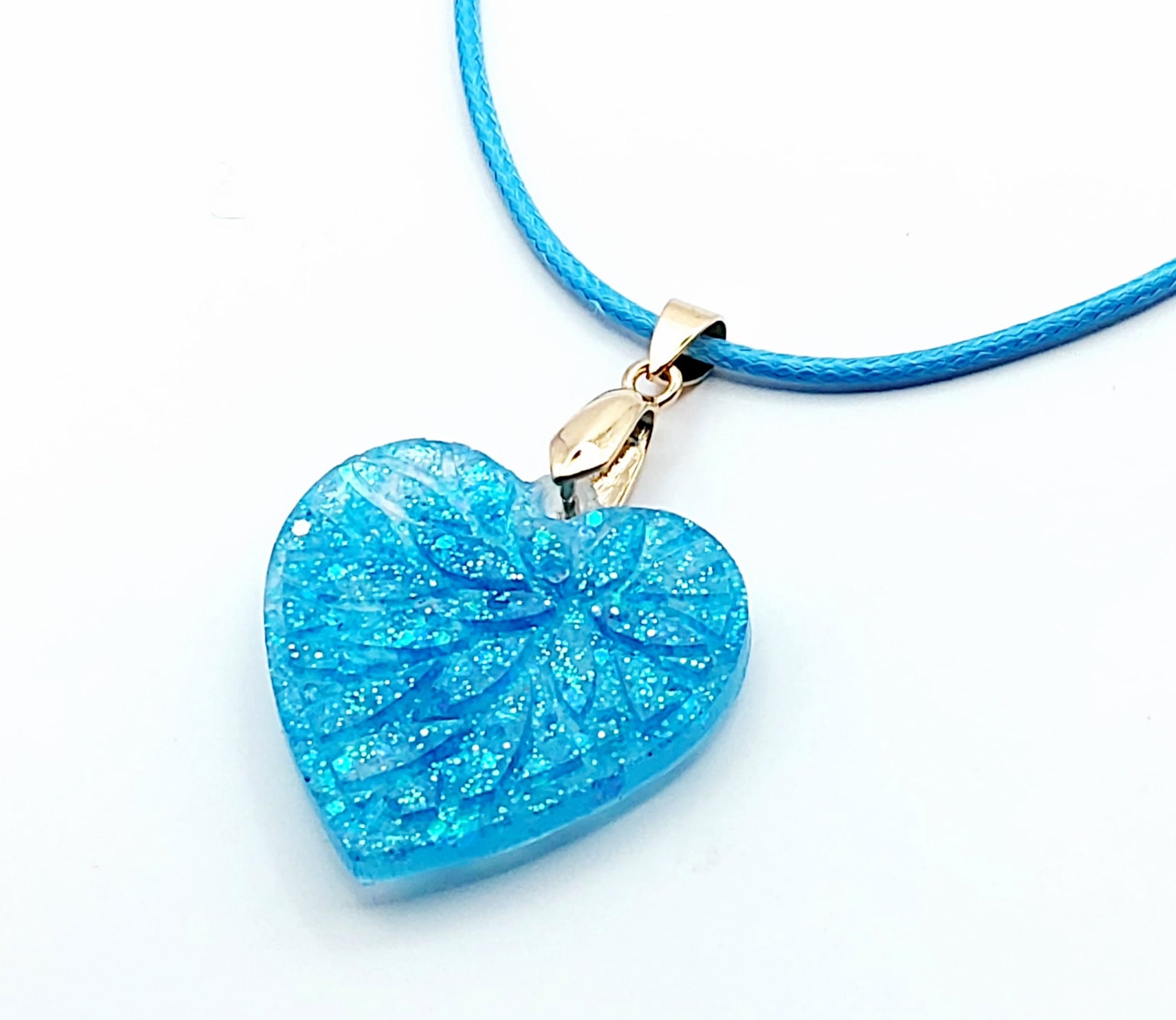 Pendentif "Petit Coeur" en résine époxy, paillettes bleues. Cordon en coton ciré bleu.