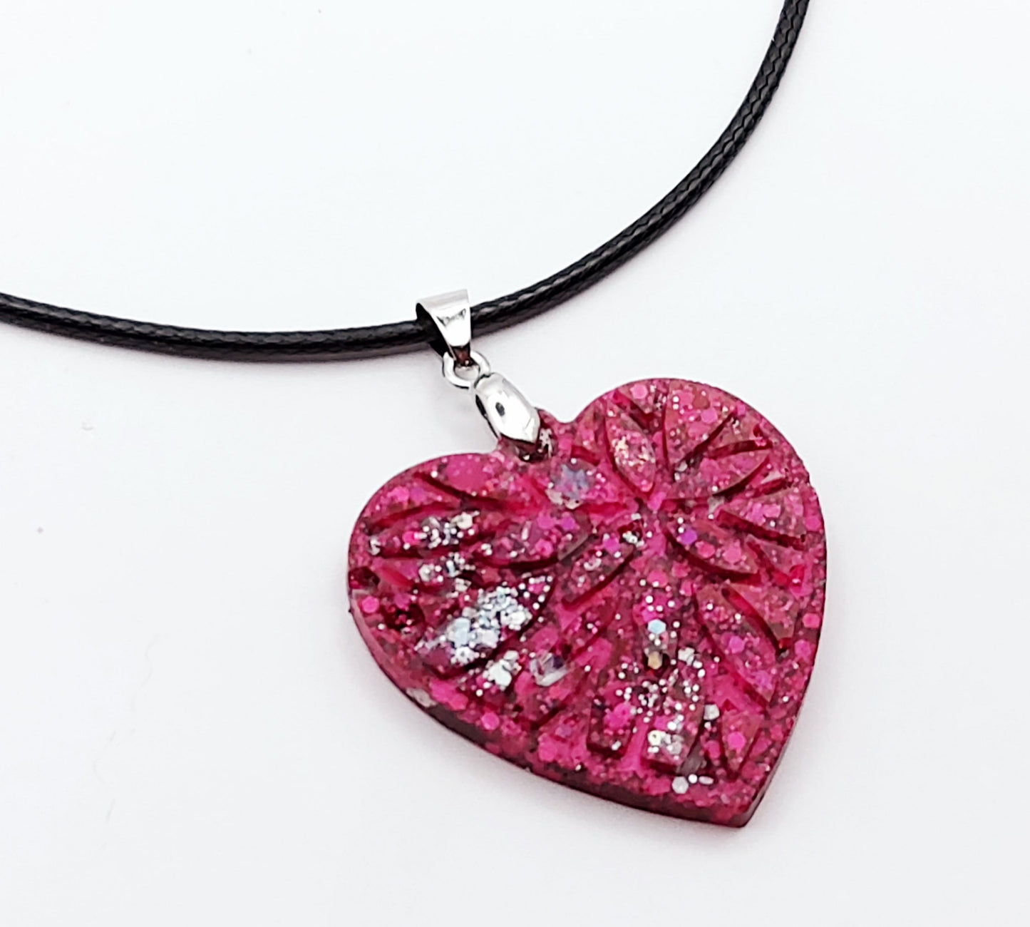 Pendentif "Petit Coeur" en résine époxy, paillettes fuchsia et argent. Gros plan de côté.