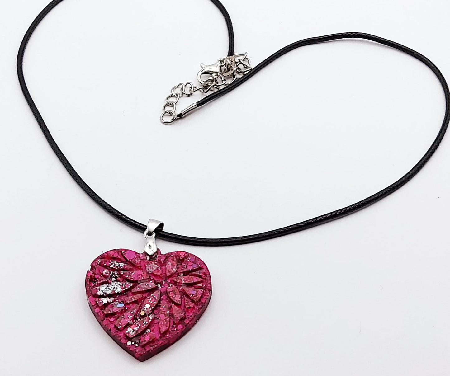 Pendentif "Petit Coeur" en résine époxy, paillettes fuchsia et argent. Plan large.