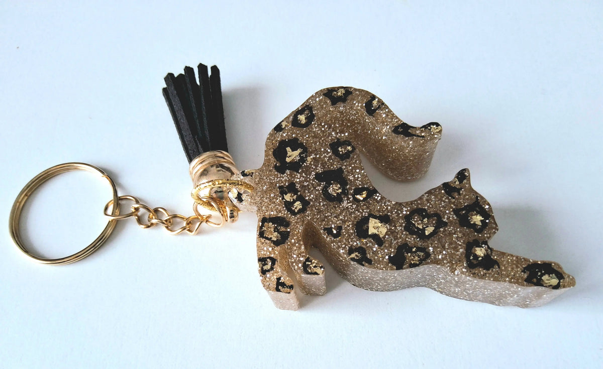 Porte-clés CHAT QUI S'ETIRE en résine époxy. Paillettes or. Motif léopard. Pompon gland noir - PRETTY RESINE
