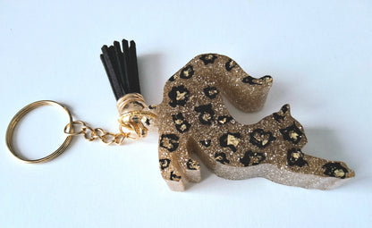 Porte-clés CHAT QUI S'ETIRE en résine époxy. Paillettes or. Motif léopard. Pompon gland noir - PRETTY RESINE
