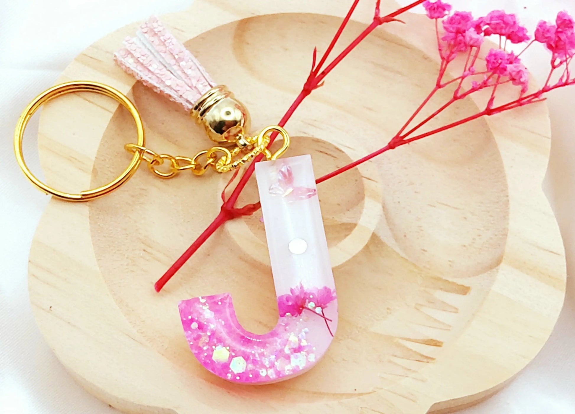 Porte-clés LETTRE J en résine époxy. Fond blanc, paillettes, fleurs et papillon roses. Pompon gland pailleté rose - PRETTY RESINE