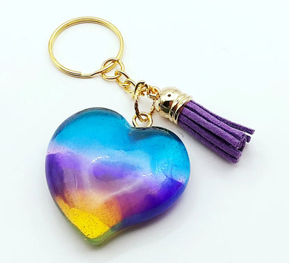 Porte-clés "Gros Coeur" en résine époxy. Multicolore et translucide. Anneau doré. Pompon gland violet.