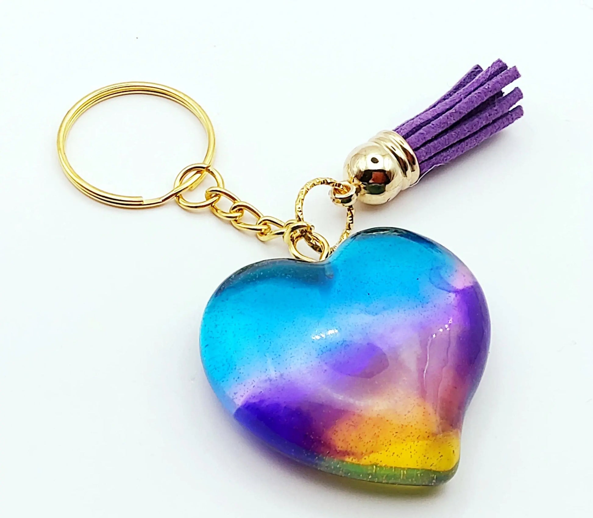 Porte-clés "Gros Coeur" en résine époxy. Multicolore et translucide. Anneau doré. Pompon gland violet.