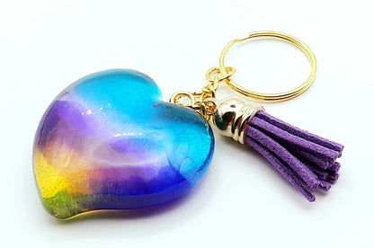 Porte-clés "Gros Coeur" en résine époxy. Multicolore et translucide. Anneau doré. Pompon gland violet.
