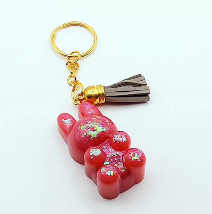 Porte-clés "Lapin Mignon" en résine époxy. Rose et paillettes holographiques. Anneau doré. Pompon gland gris clair.