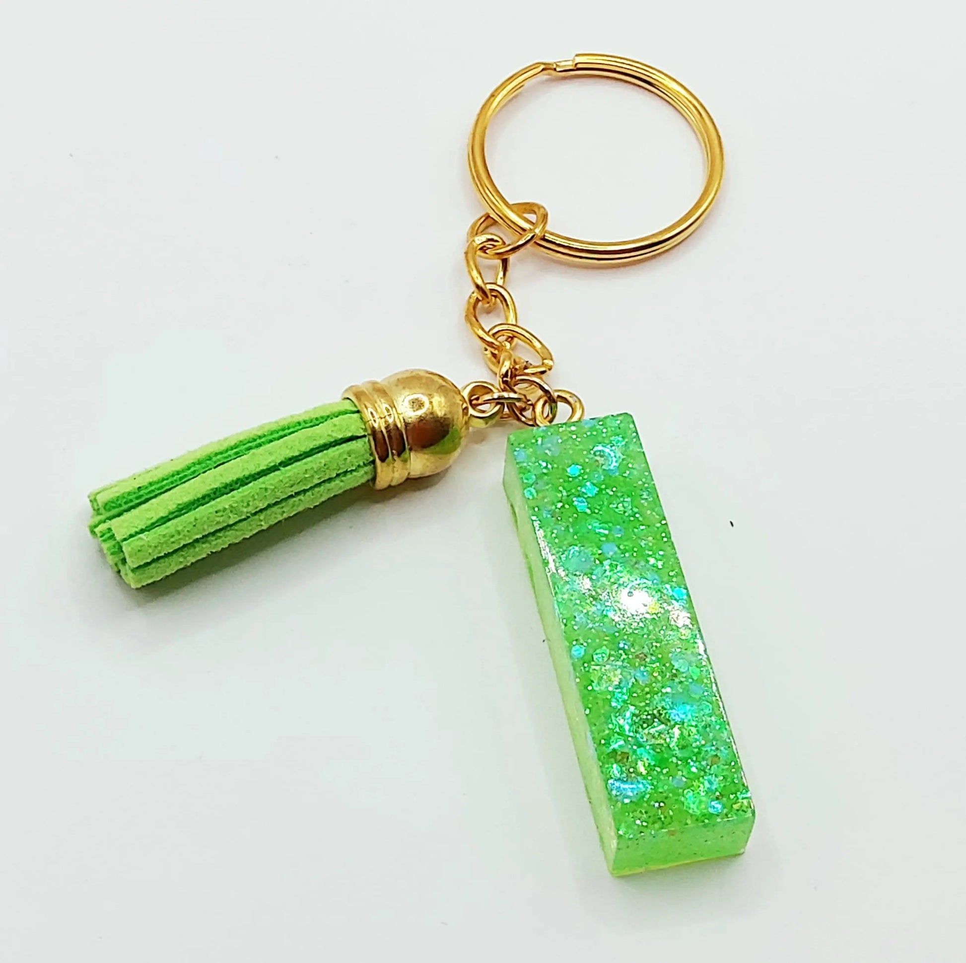 Porte-clés "Lettre I" en résine époxy, paillettes holographiques vertes, pompon gland vert, anneau doré.