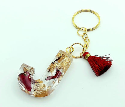 Porte-clés "Lettre J" en résine époxy, Pétales de roses et feuille d'or, pompon gland rouge, anneau doré