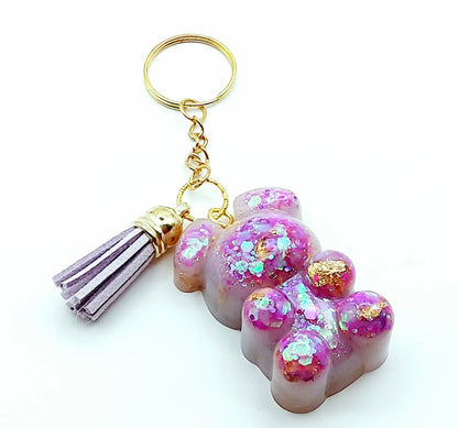 Porte-clés "Ourson debout" en résine époxy, mauve et paillettes holographiques roses. Anneau doré et pompon gland mauve.