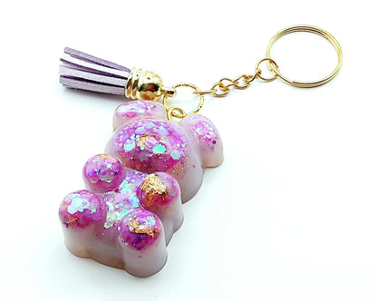 Porte-clés "Ourson debout" en résine époxy, mauve et paillettes holographiques roses. Anneau doré et pompon gland mauve.