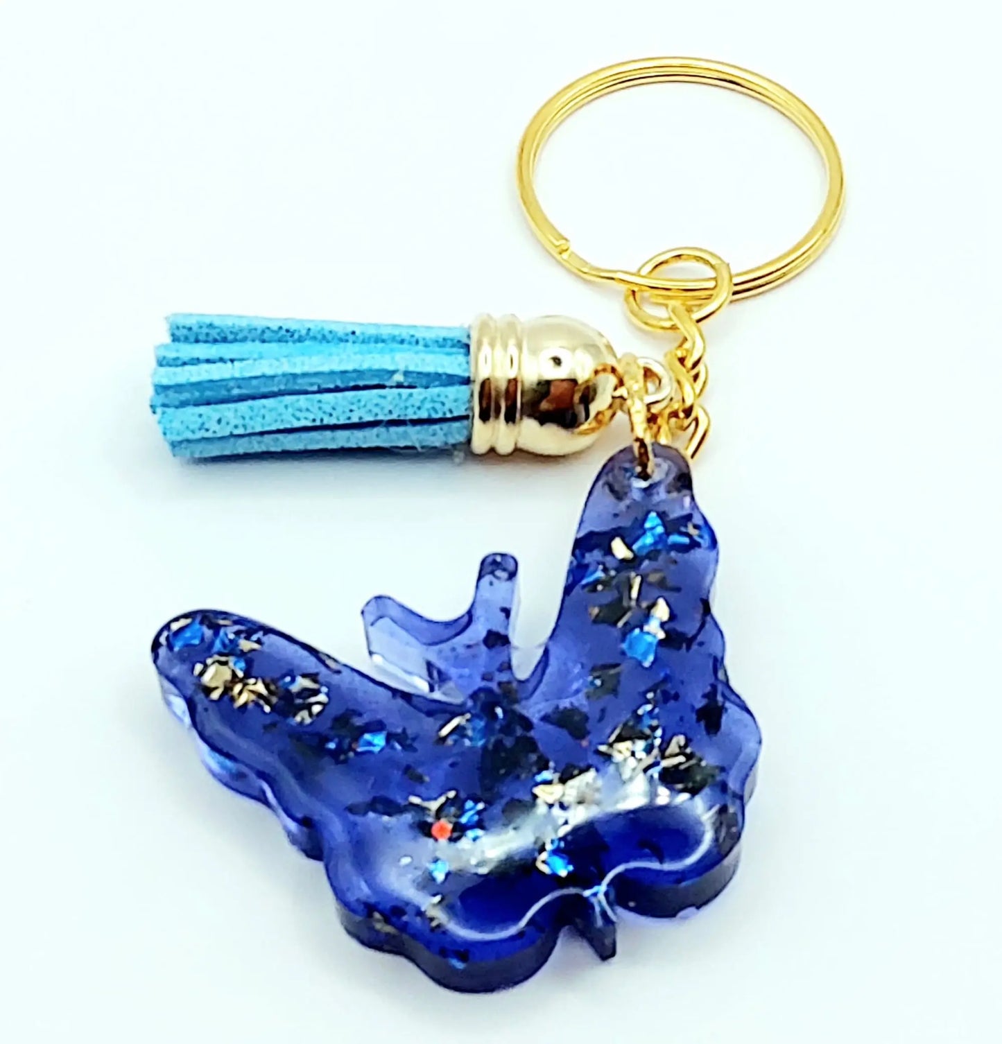 Porte-clés "Papillon" en résine époxy. Bleu et feuille d'or. Anneau doré. Pompon gland bleu ciel.