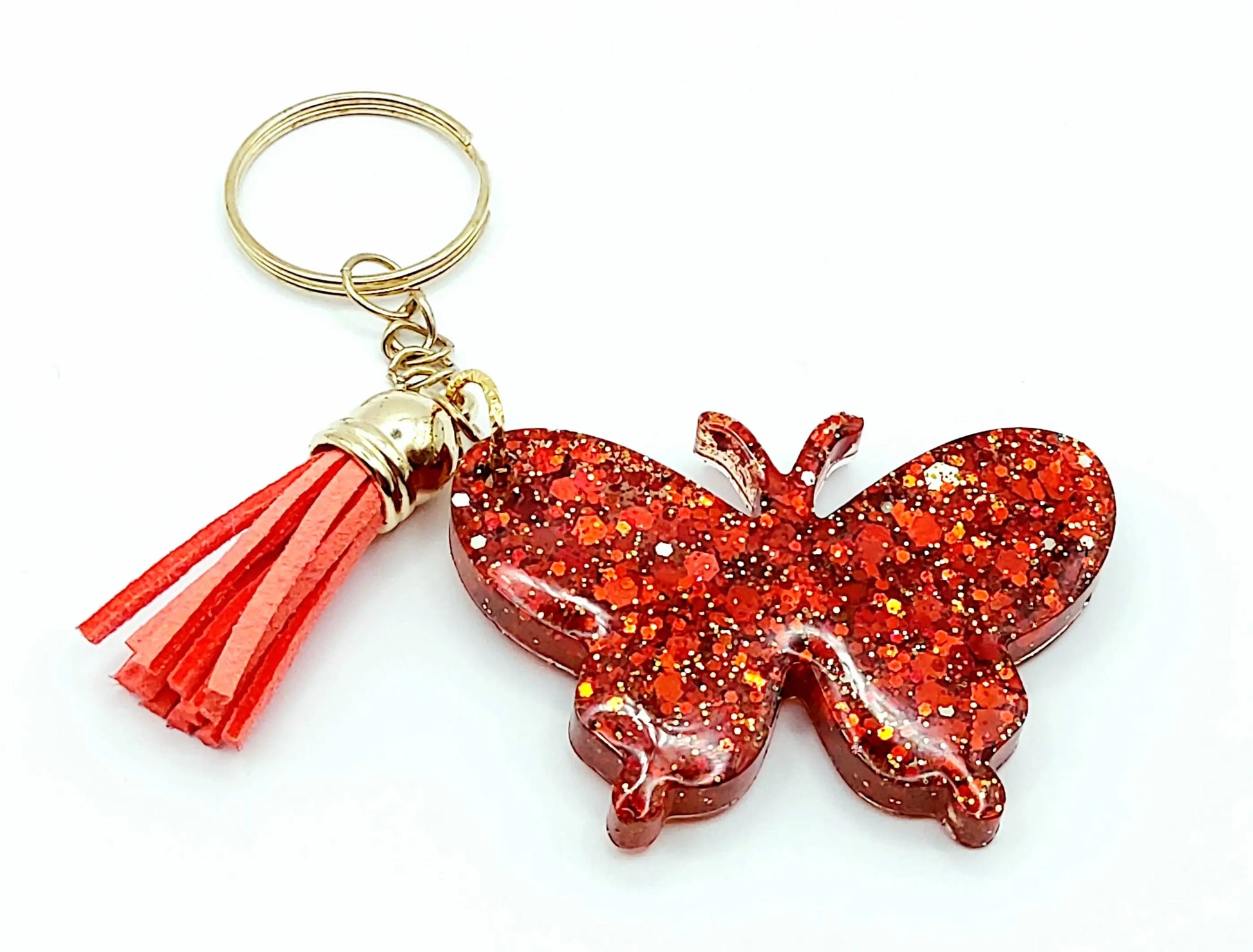 Porte-clés "Papillon" en résine époxy. Paillettes rouges, anneau doré, pompon gland rouge.