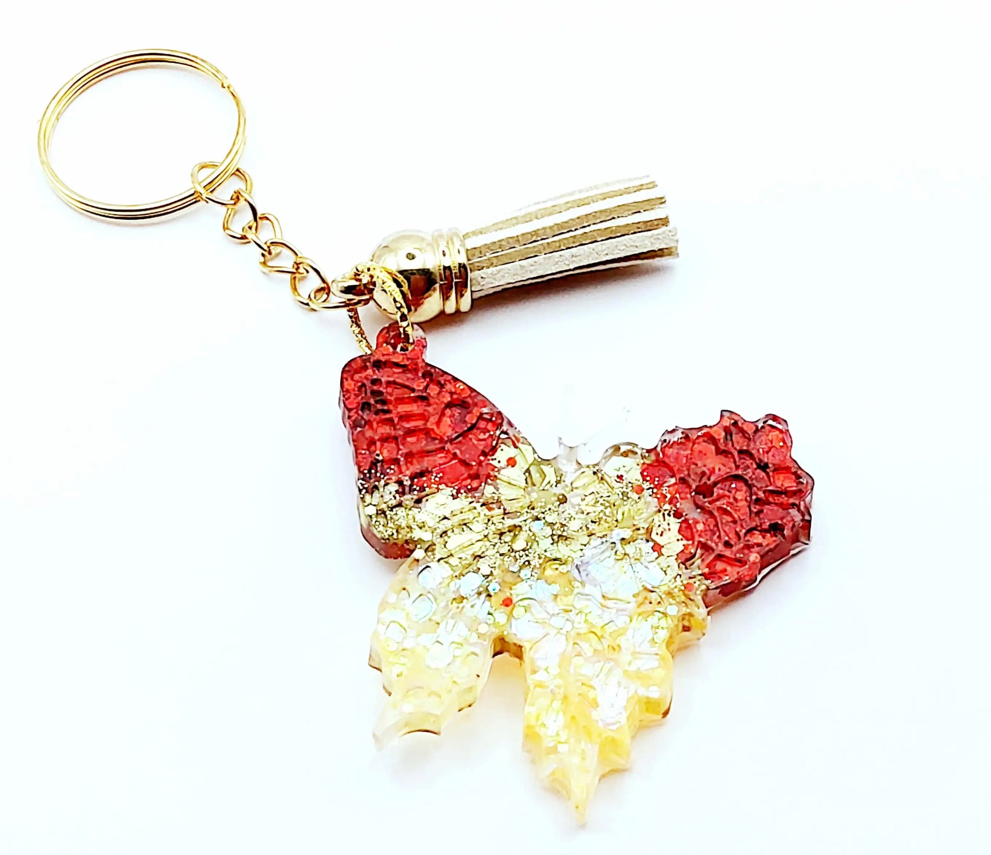 Porte-clés "Papillon" en résine époxy, paillettes rouges et or. Anneau doré, pompon gland beige. 