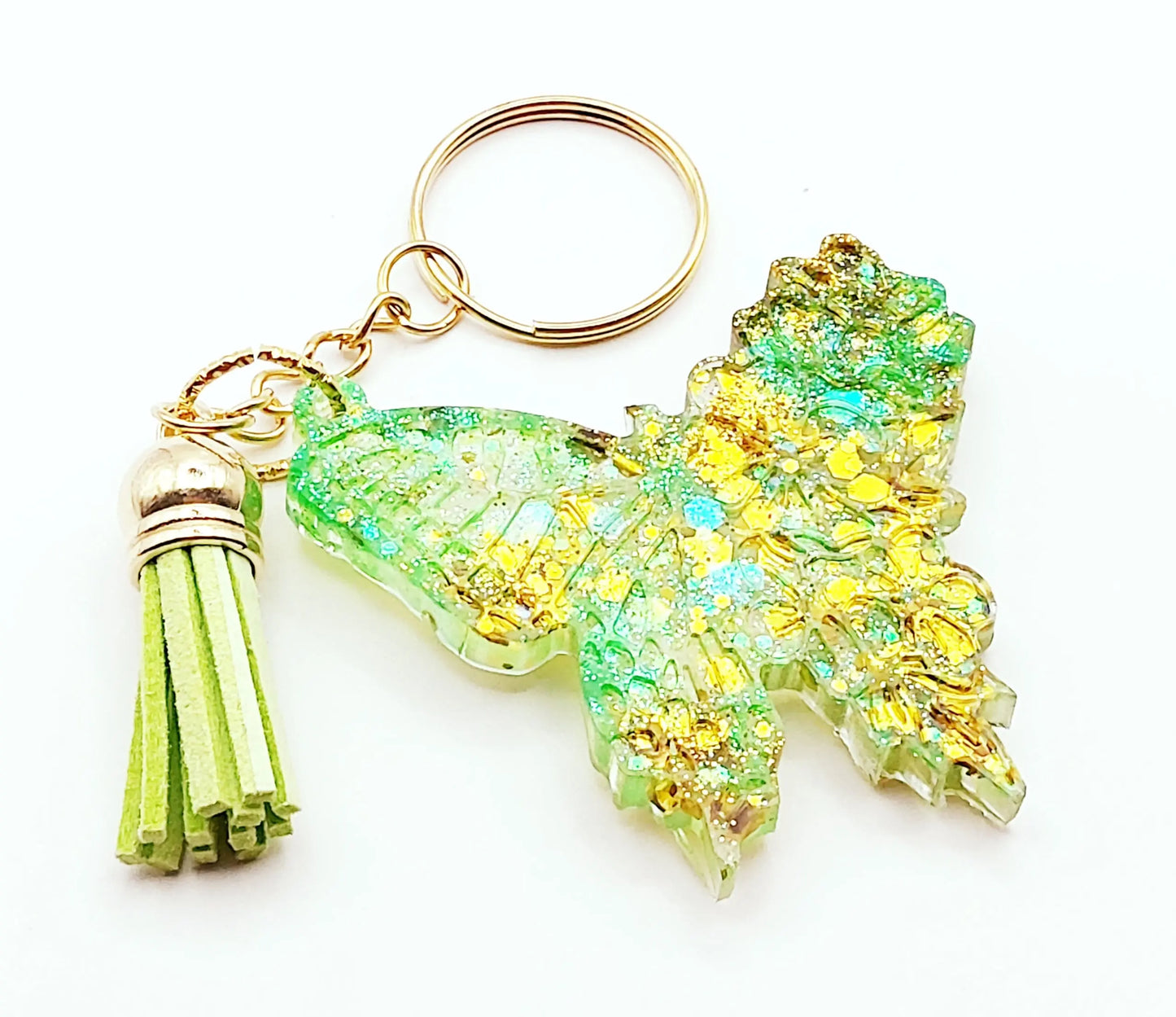 Porte-clés "Papillon" en résine époxy. Paillettes vertes et dorées, pompon gland vert, anneau doré