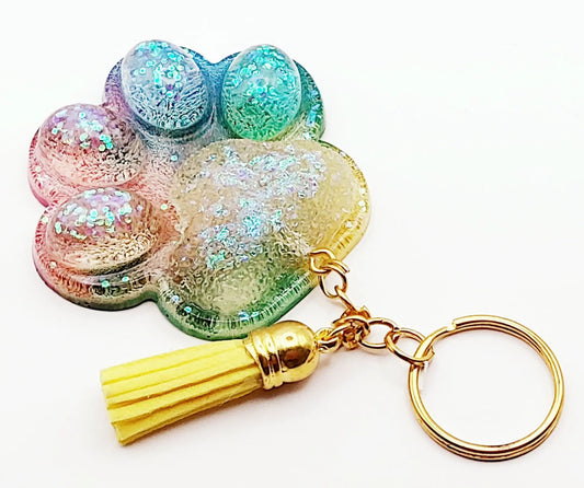 Porte-clés "Patte d'ours" en résine époxy. Multicolore, anneau doré, pompon gland jaune.