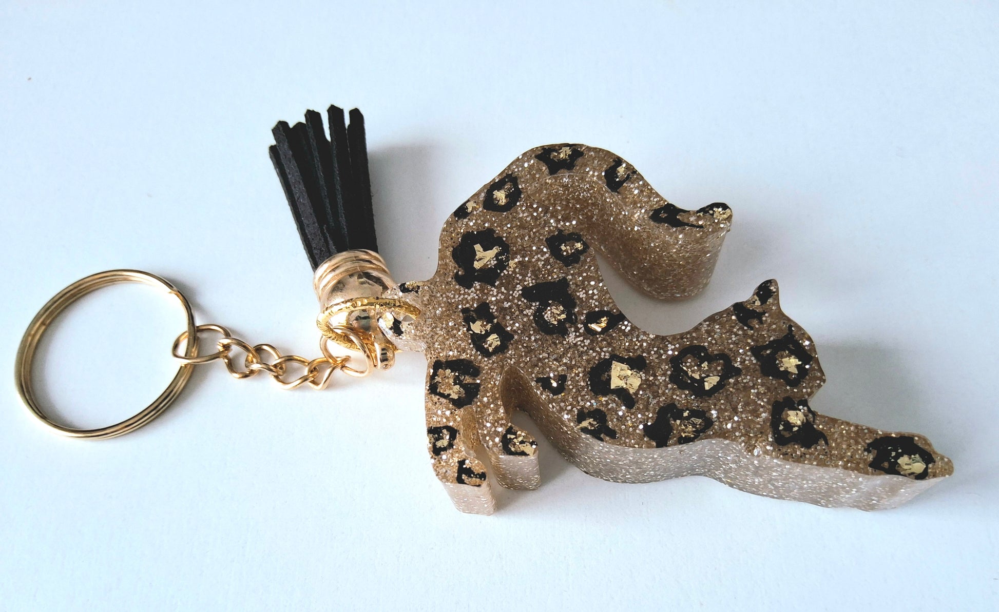 Porte-clés CHAT QUI S'ETIRE en résine époxy. Paillettes or. Motif léopard. Pompon gland noir - PRETTY RESINE