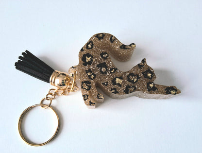 Porte-clés CHAT QUI S'ETIRE en résine époxy. Paillettes or. Motif léopard. Pompon gland noir - PRETTY RESINE