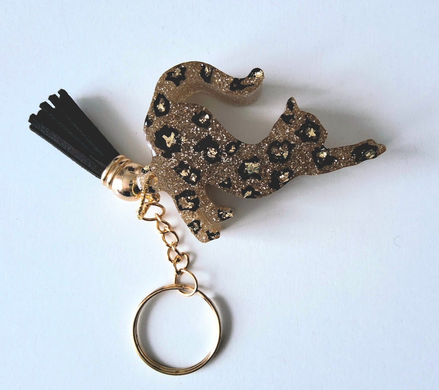 Porte-clés CHAT QUI S'ETIRE en résine époxy. Paillettes or. Motif léopard. Pompon gland noir - PRETTY RESINE