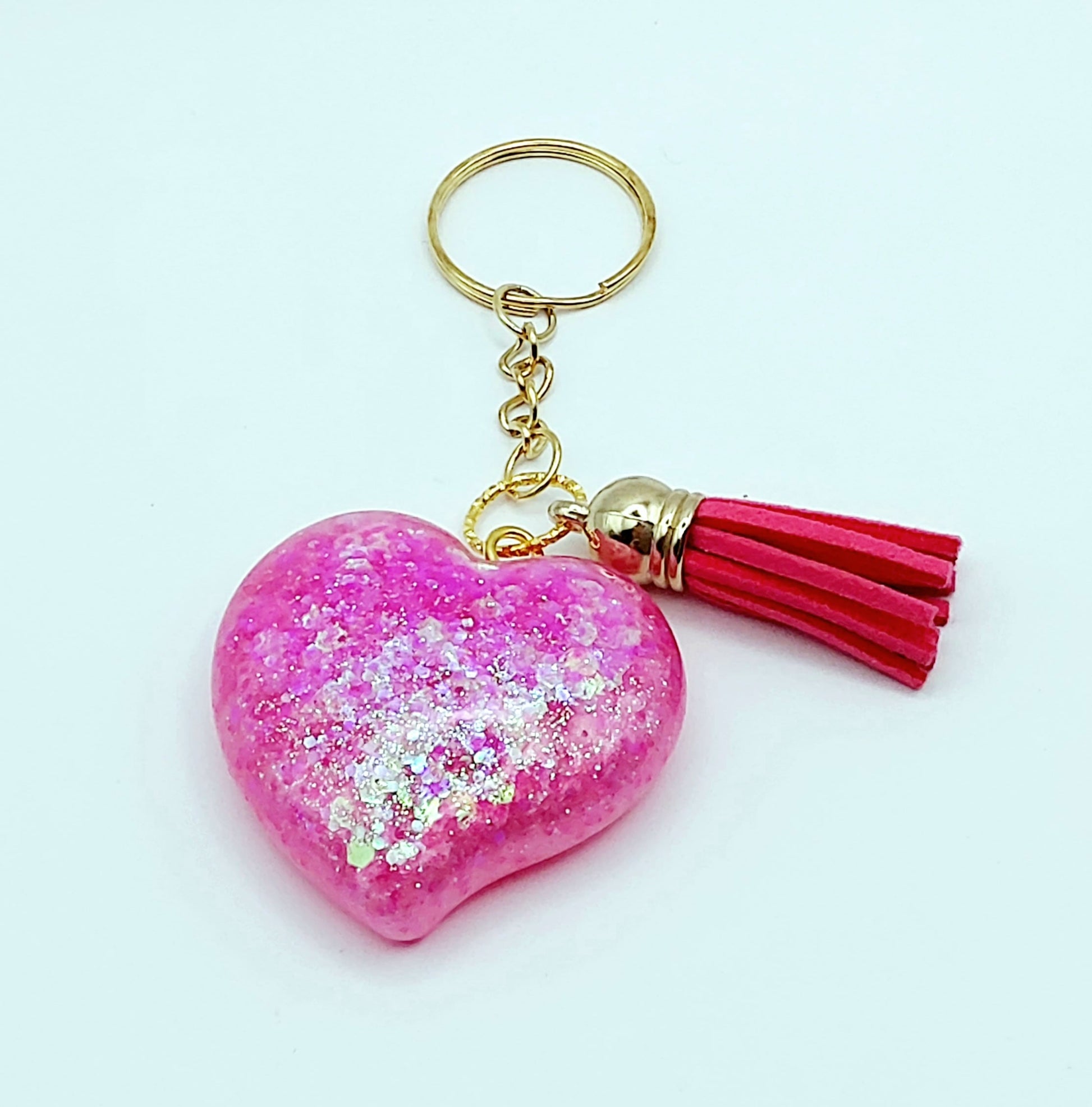 Porte-clés "Gros Coeur" en résine époxy, paillettes holographiques roses, pompon gland rose fuchsia, anneau doré.