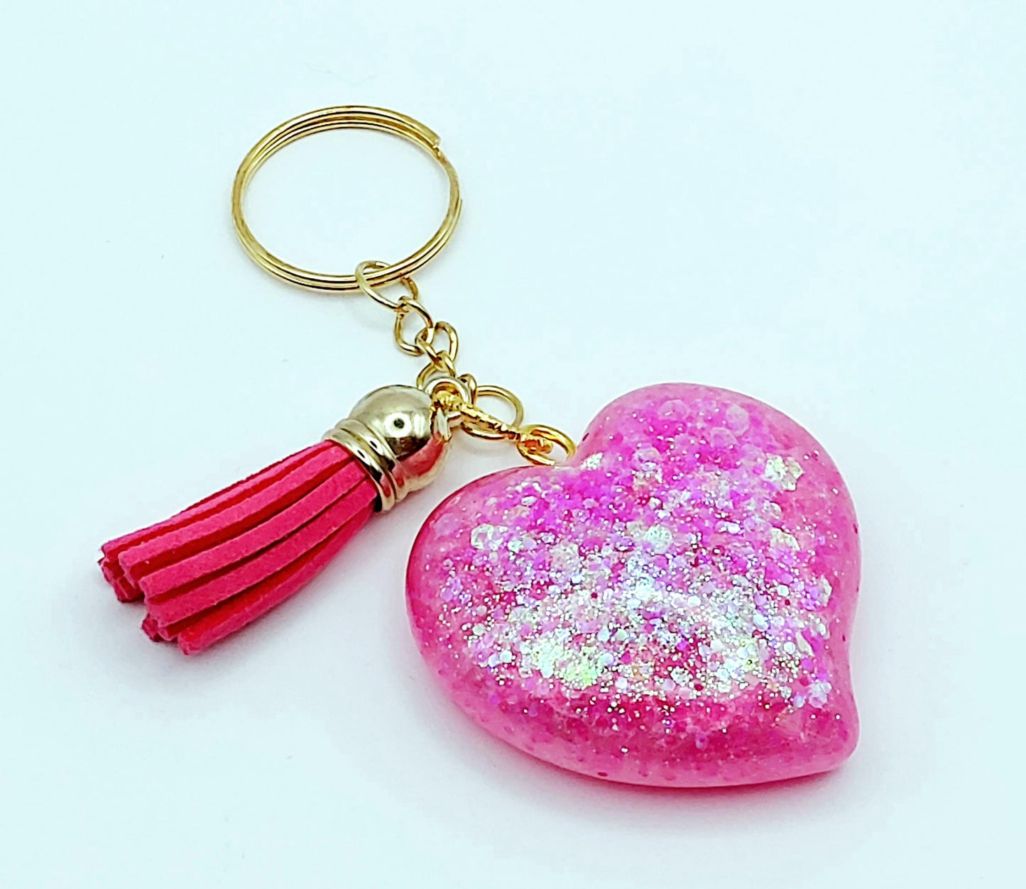 Porte-clés "Gros Coeur" en résine époxy, paillettes holographiques roses, pompon gland rose fuchsia, anneau doré.