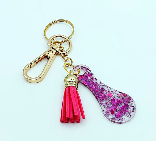 Porte-clés Jeton de caddie en résine époxy, blanc irisé et paillettes fuchsia. Pompon gland rose fuchsia, Anneau et mousqueton doré.