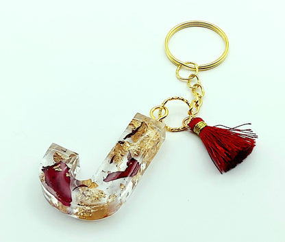 Porte-clés "Lettre J" en résine époxy, Pétales de roses et feuille d'or, pompon gland rouge, anneau doré