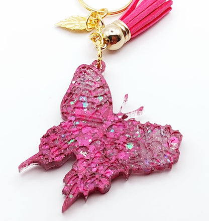 Porte-clés "Papillon" en résine époxy, paillettes et pompon gland roses fuchsia