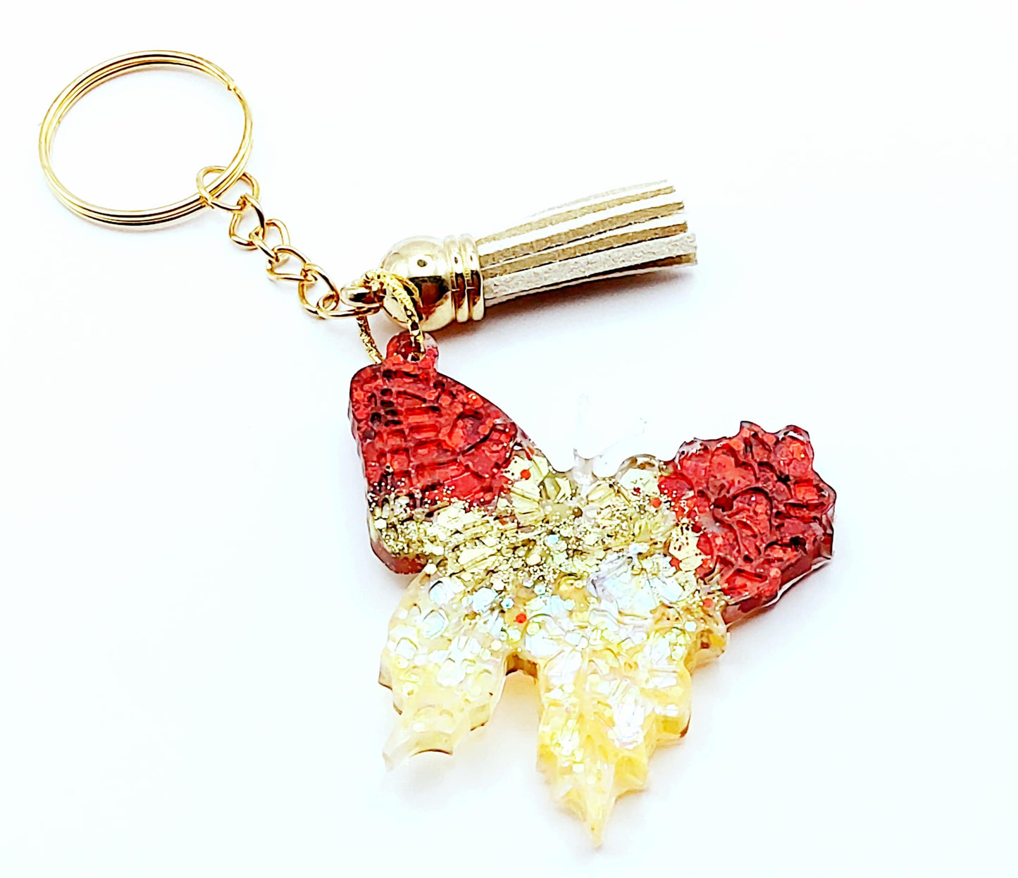 Porte-clés "Papillon" en résine époxy, paillettes rouges et or. Anneau doré, pompon gland beige. 