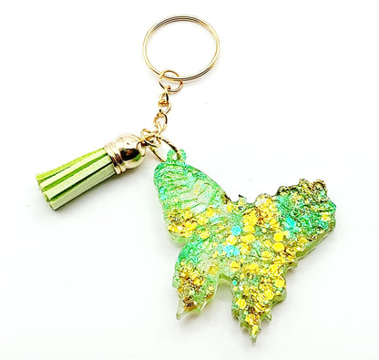 Porte-clés "Papillon" en résine époxy. Paillettes vertes et dorées, pompon gland vert, anneau doré.